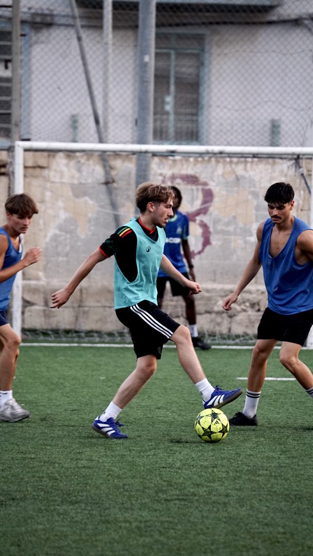 A player dribbling past two defenders in a five-a-side game
